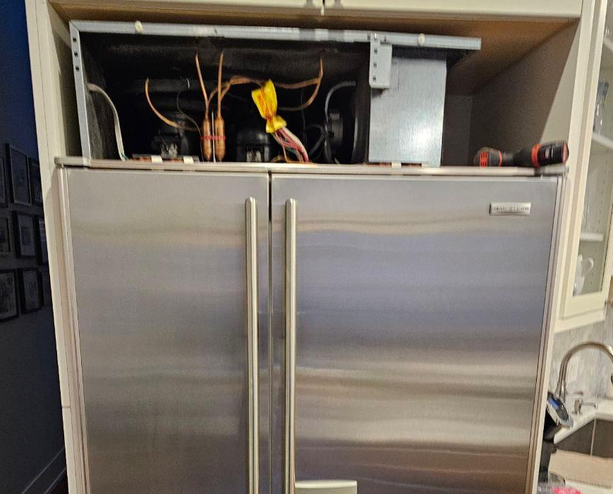 Sub-Zero built-in refrigerator opened at top service panel during sealed system repair and cooling diagnostics