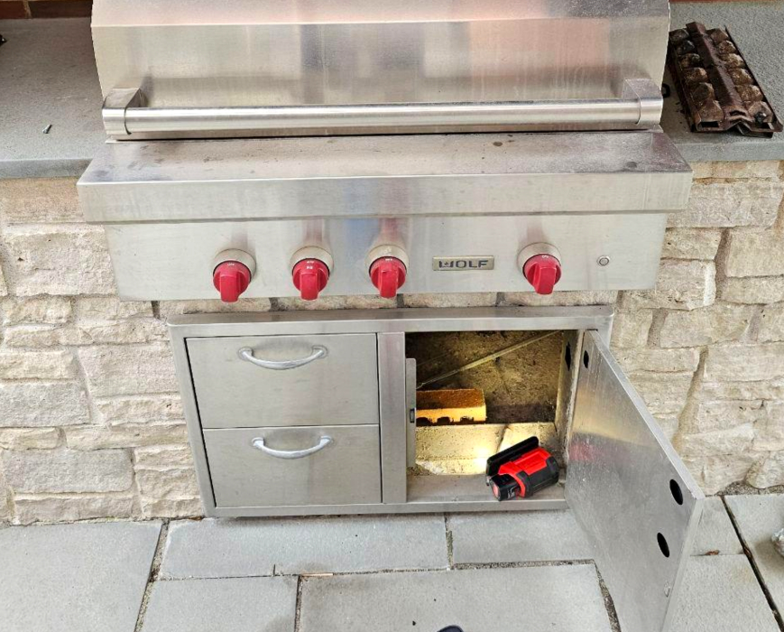 Wolf outdoor built-in grill during gas valve repair with lower access panel opened for service