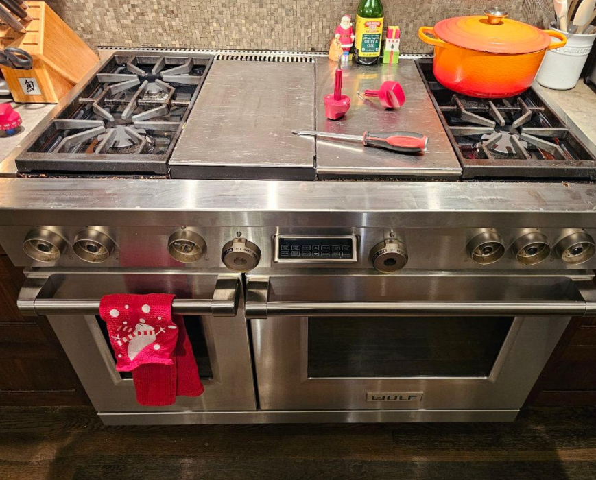 Wolf professional range during ignition switch service with control knobs removed and tools on cooktop